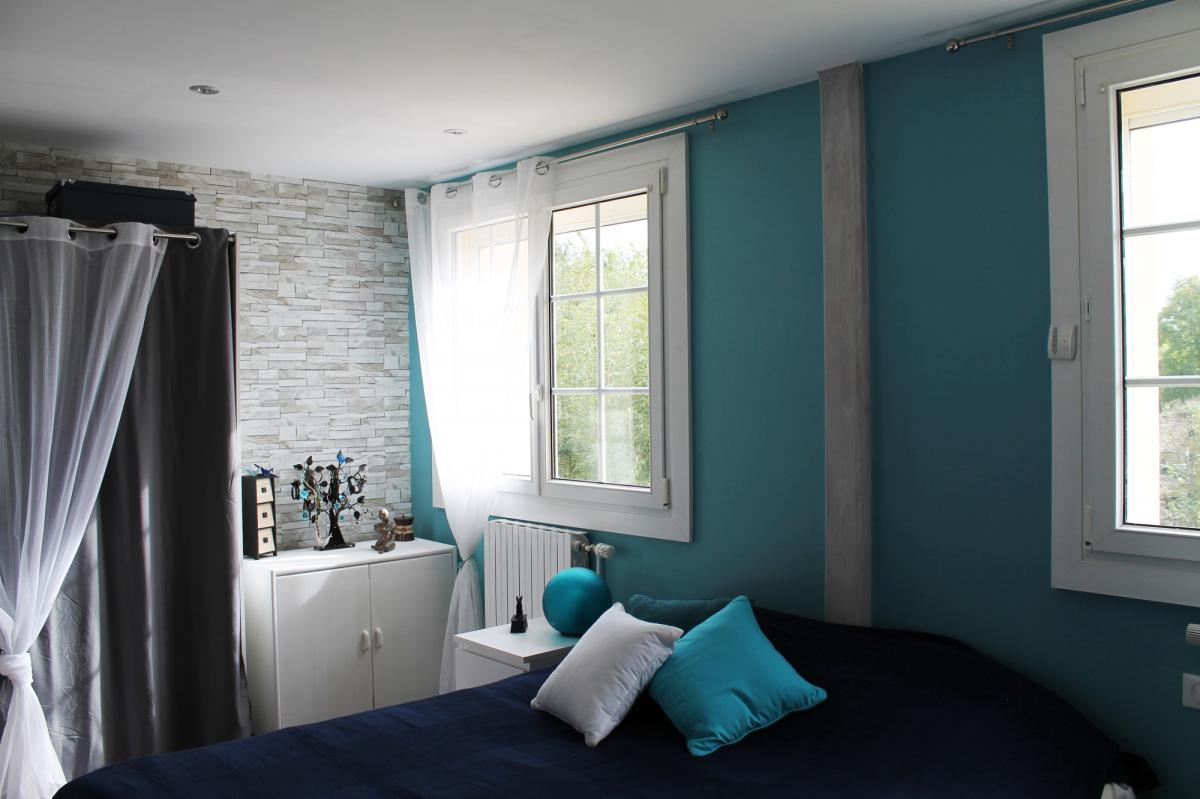 Alliance de Turquoise - Bleu - Gris, rehaussé par un parquet massif en chêne foncé.